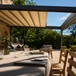 Pergola retractable : ombre sur terrasse en pierre et lumière le soir