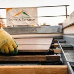 Terrasse sur toiture inclinée : ouvrier pose des dalles sur plots